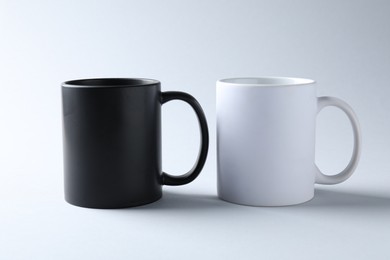 Photo of Mugs on light background. Mockup for design