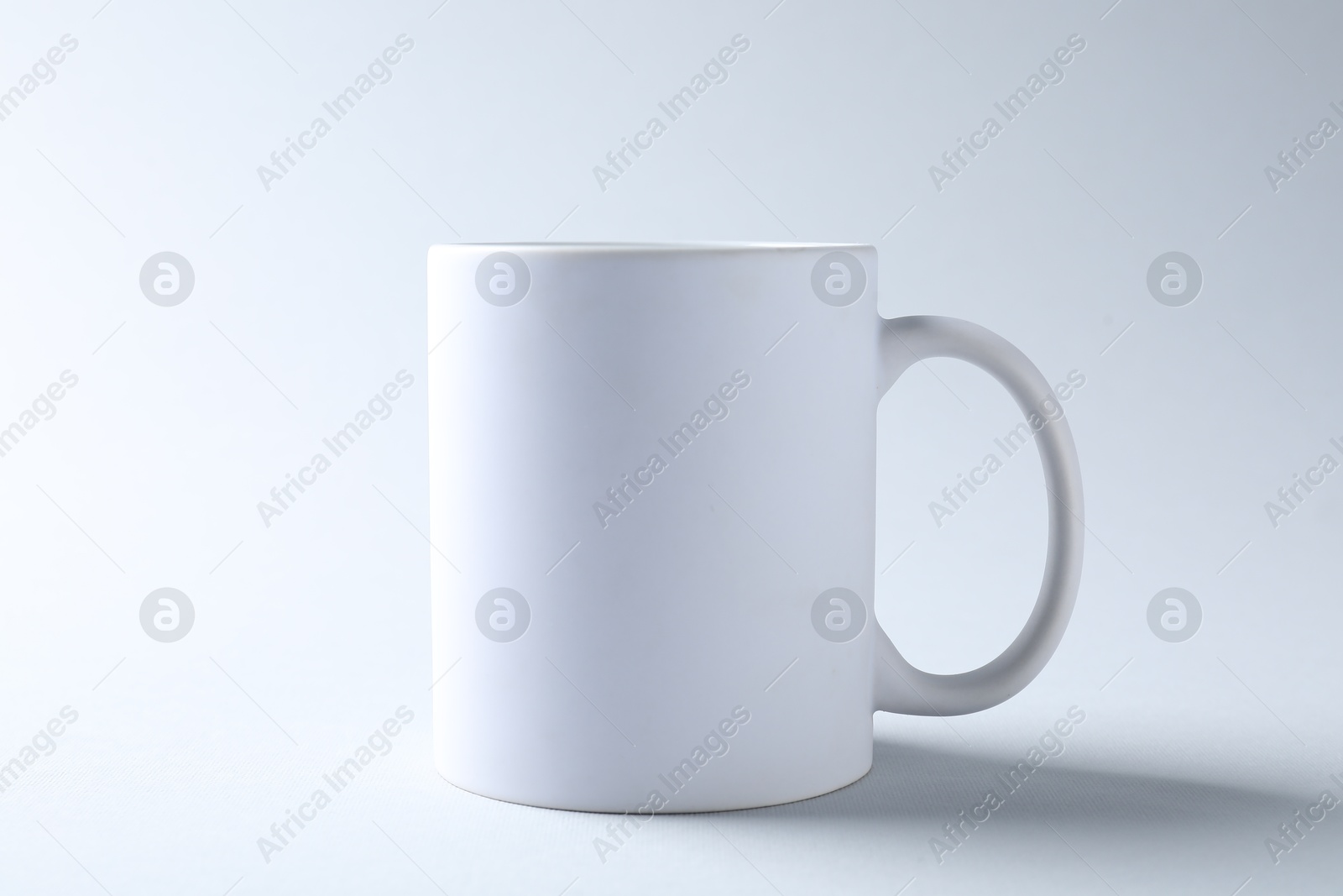 White mug on light background. Mockup for design Photo of White mug on light background. Mockup for design