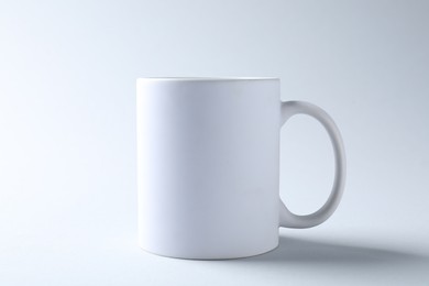 Photo of White mug on light background. Mockup for design