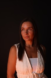 Photo of Attractive woman in neon lights against black background