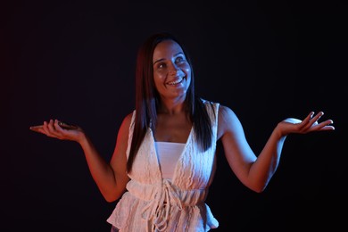 Photo of Portrait of smiling woman in neon lights against dark background