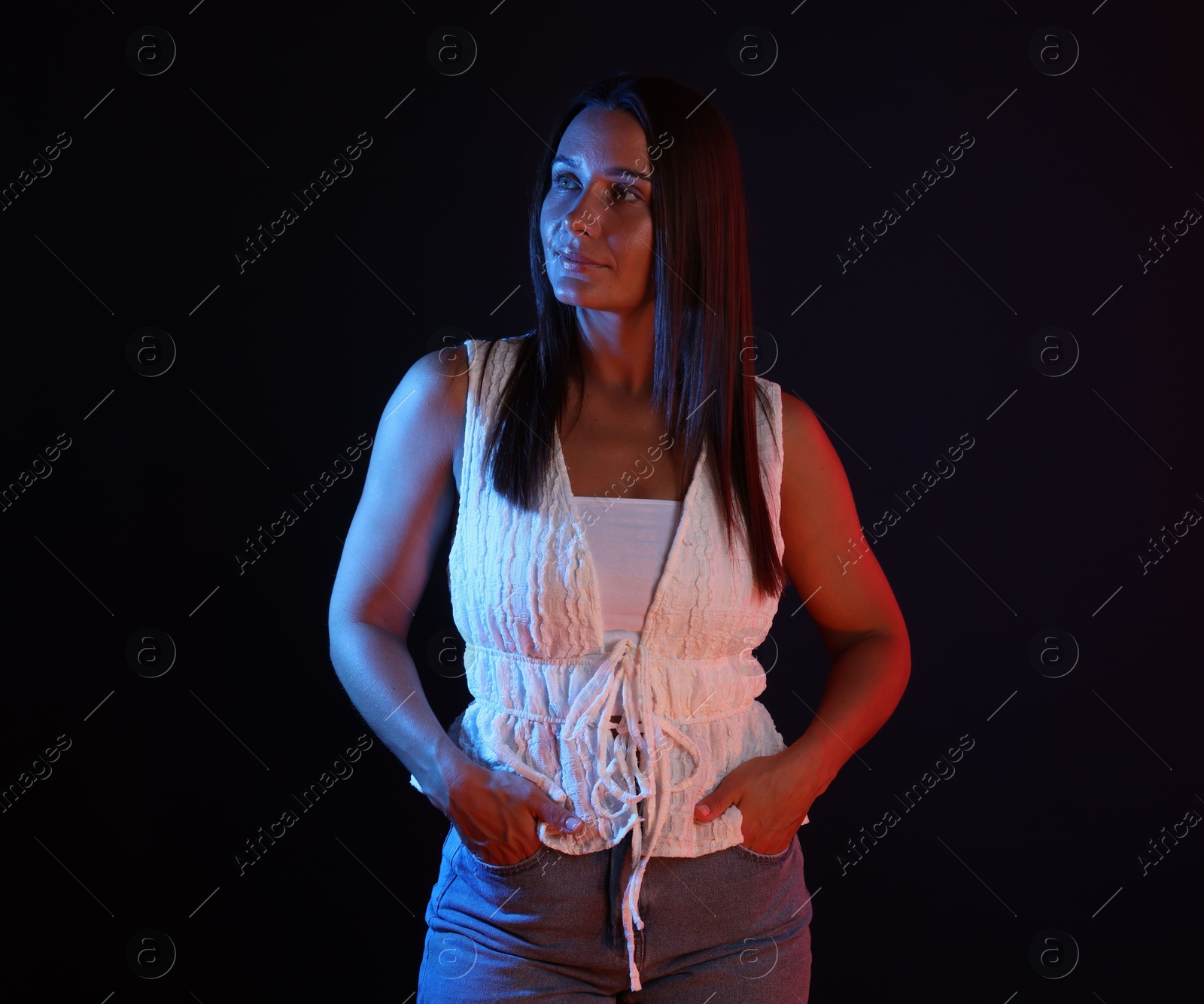 Attractive woman in neon lights against black background Photo of Attractive woman in neon lights against black background
