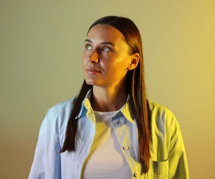 Photo of Beautiful woman in neon lights against color background