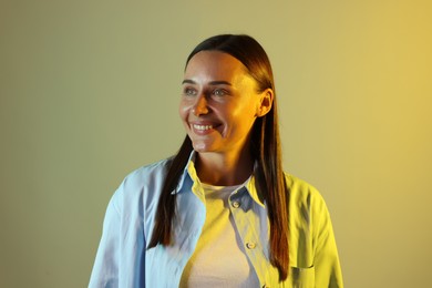 Photo of Smiling woman in neon lights against color background