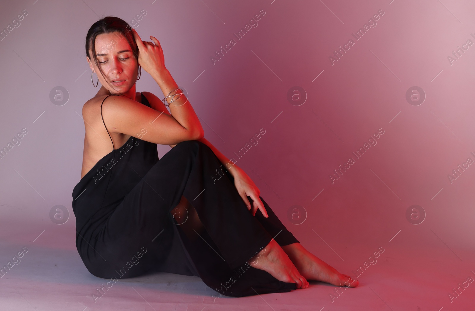 Beautiful woman wearing dress posing in neon lights against color background. Space for text Photo of Beautiful woman wearing dress posing in neon lights against color background. Space for text