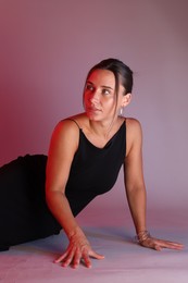 Photo of Beautiful woman wearing dress posing in neon lights against color background