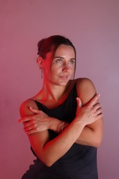 Photo of Beautiful woman with bracelet in neon lights against color background