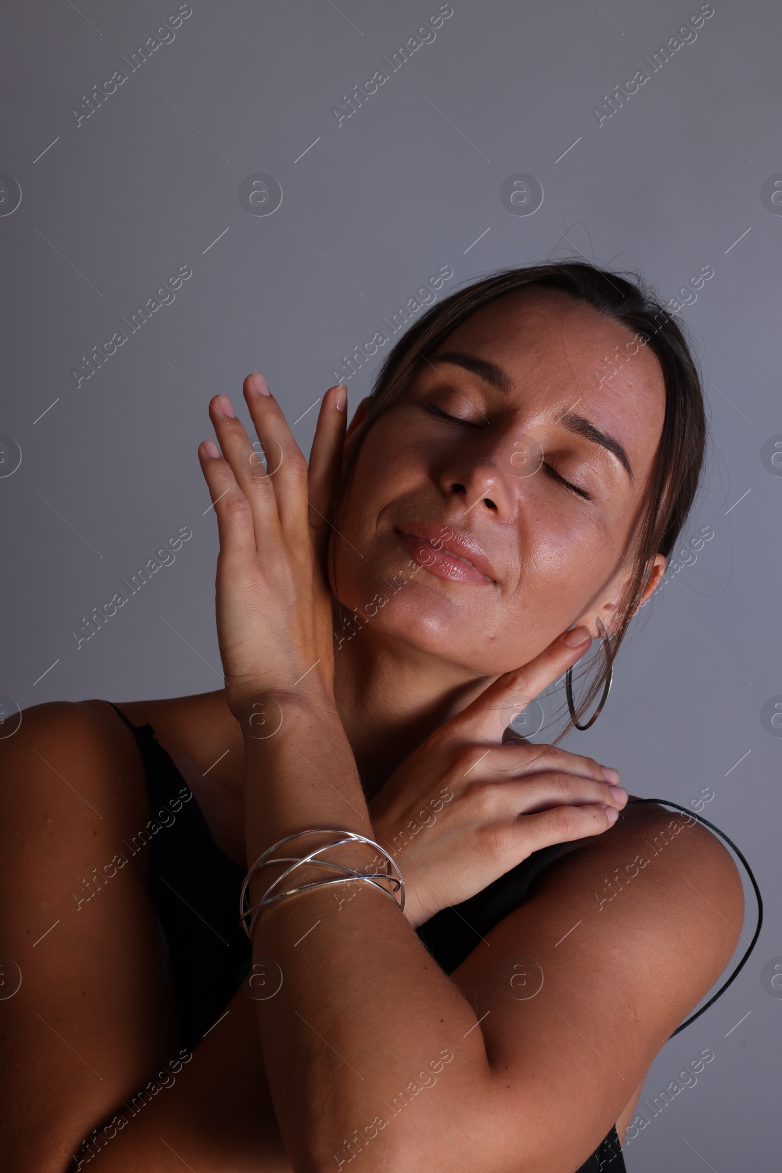 Beautiful woman with bracelet on grey background Photo of Beautiful woman with bracelet on grey background