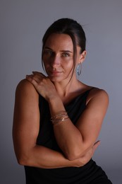 Photo of Portrait of beautiful woman with bracelet on grey background