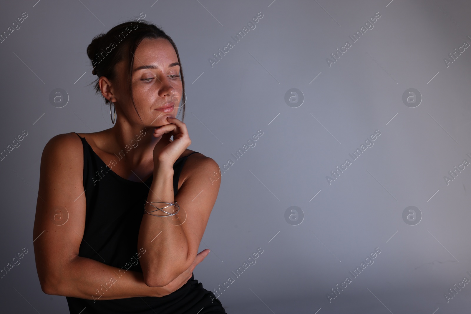 Beautiful woman on grey background. Space for text Photo of Beautiful woman on grey background. Space for text