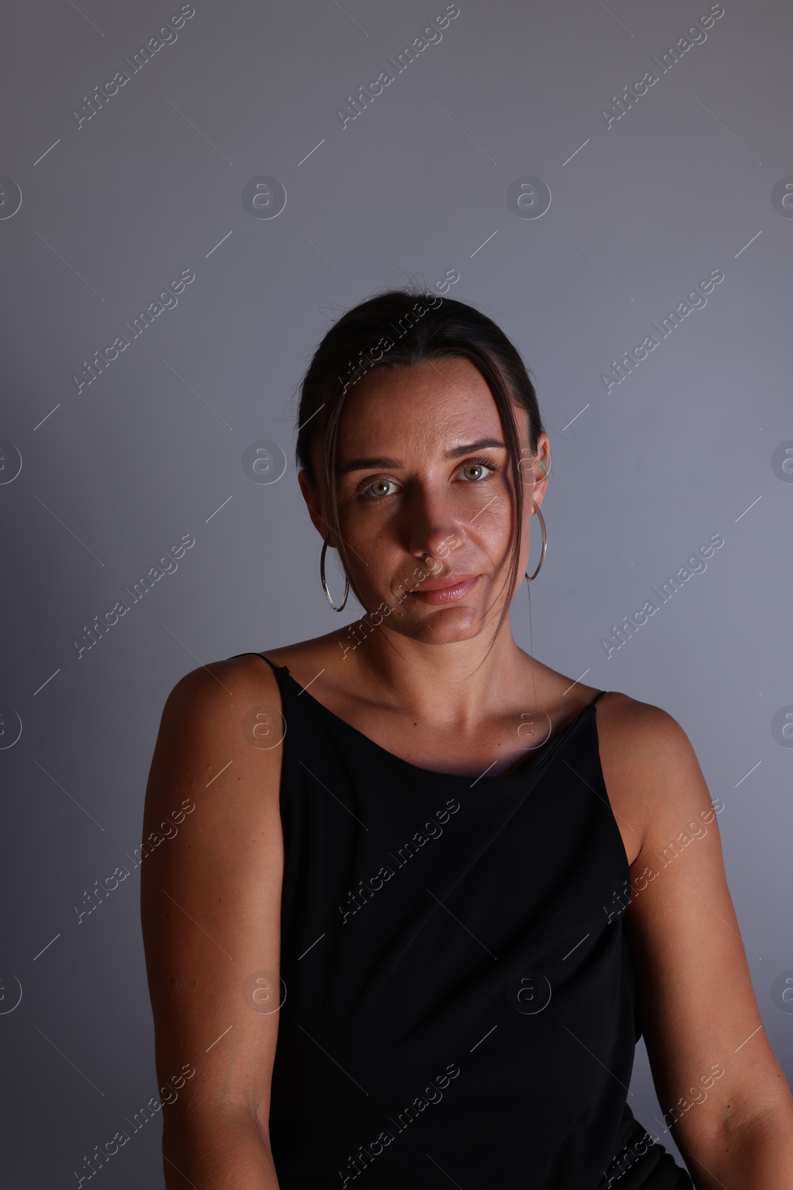 Portrait of beautiful woman on grey background Photo of Portrait of beautiful woman on grey background