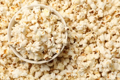 Photo of Tasty popcorn and bowl as background, closeup