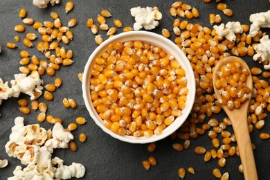 Photo of Corn kernels and tasty popcorn on black table, flat lay