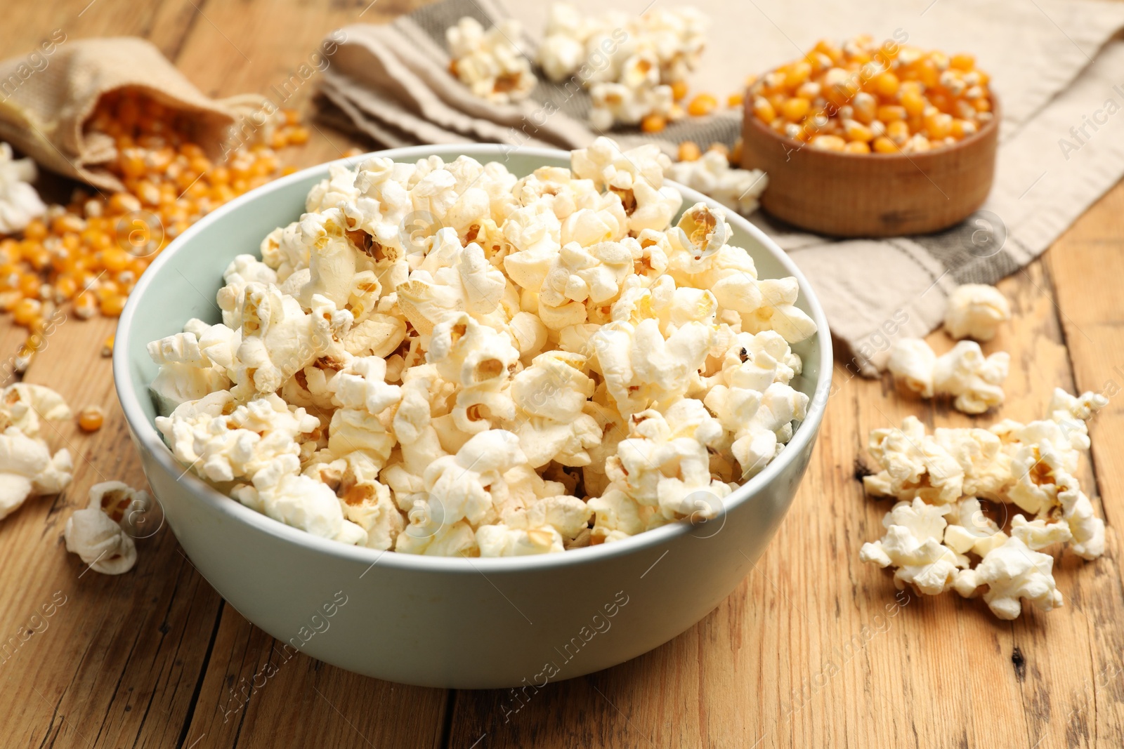 Tasty popcorn and corn kernels on wooden table, closeup Photo of Tasty popcorn and corn kernels on wooden table, closeup