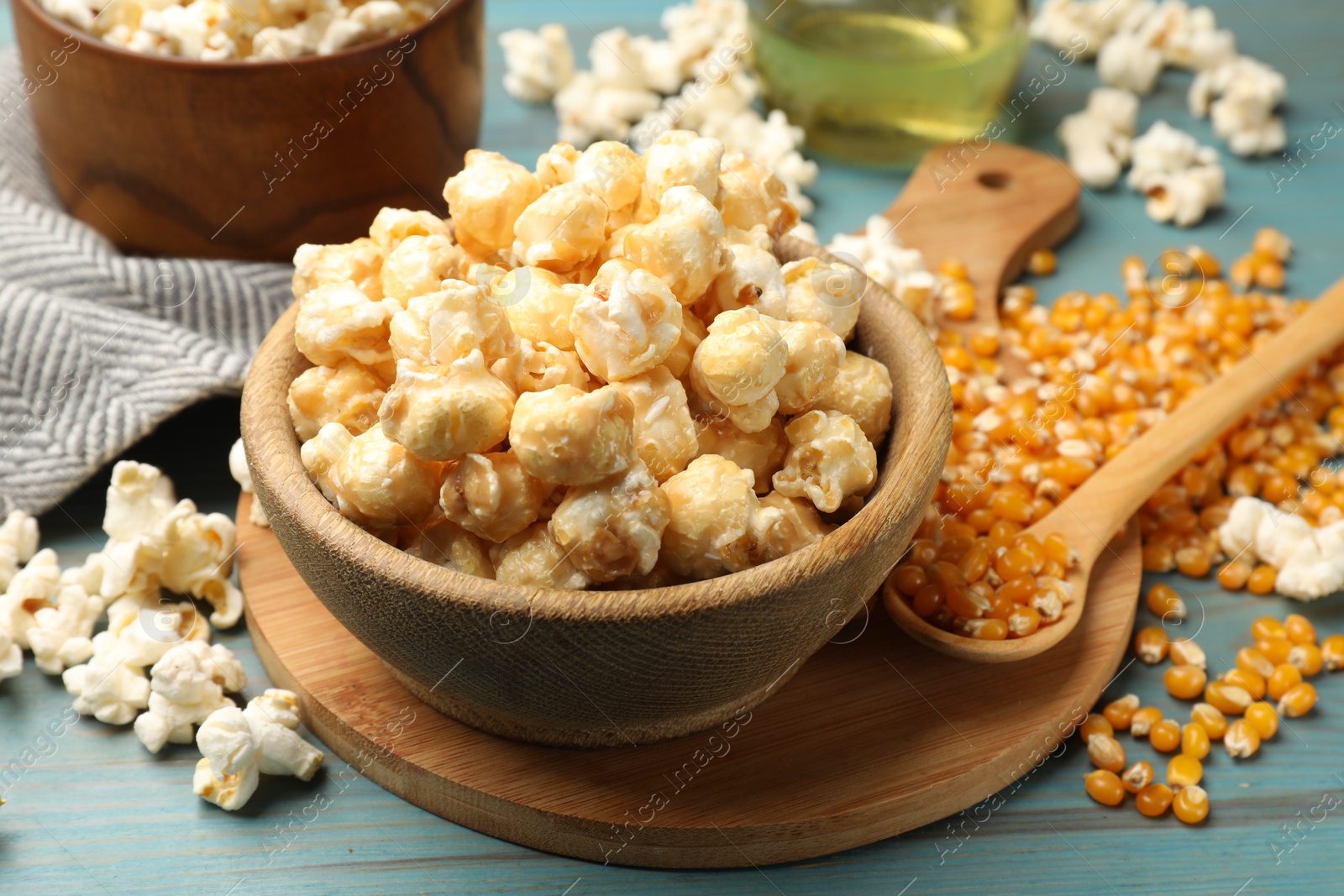 Tasty popcorn and corn kernels on blue wooden table, closeup Photo of Tasty popcorn and corn kernels on blue wooden table, closeup