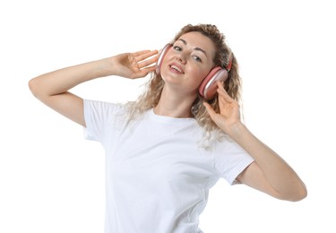 Photo of Happy woman listening to music in headphones and dancing on white background