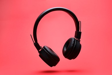 Photo of Pair of wireless headphones on coral background