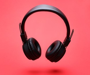Photo of Pair of wireless headphones on coral background