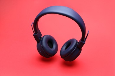 Photo of Pair of wireless headphones on coral background