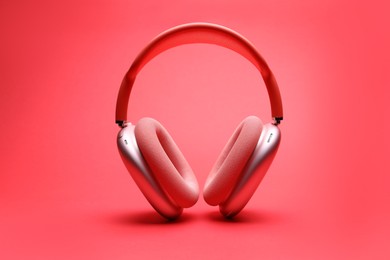 Photo of Pair of wireless headphones on coral background