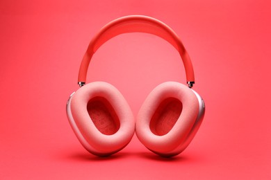 Photo of Pair of wireless headphones on coral background