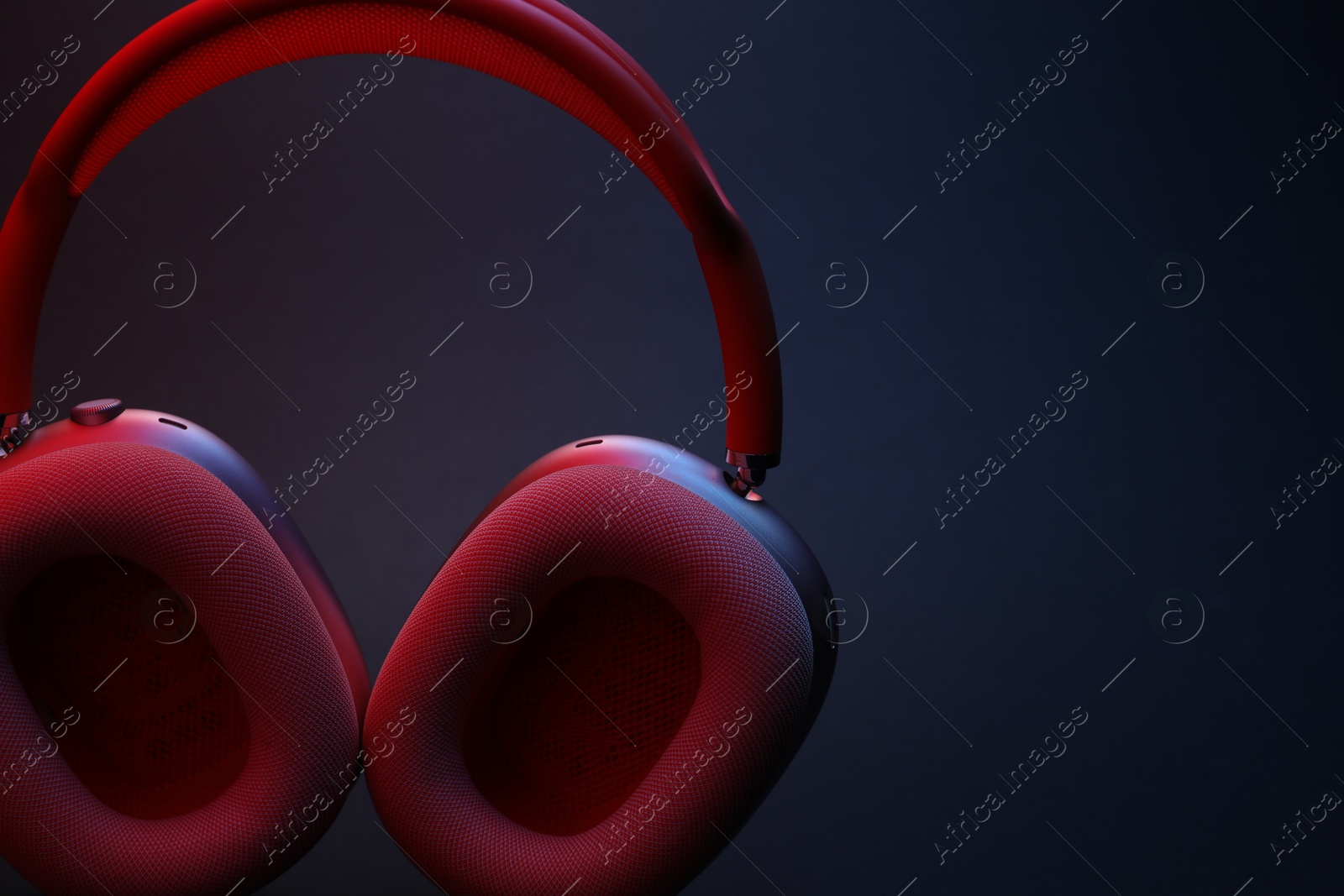 Pair of wireless headphones on dark background, closeup. Space for text Photo of Pair of wireless headphones on dark background, closeup. Space for text