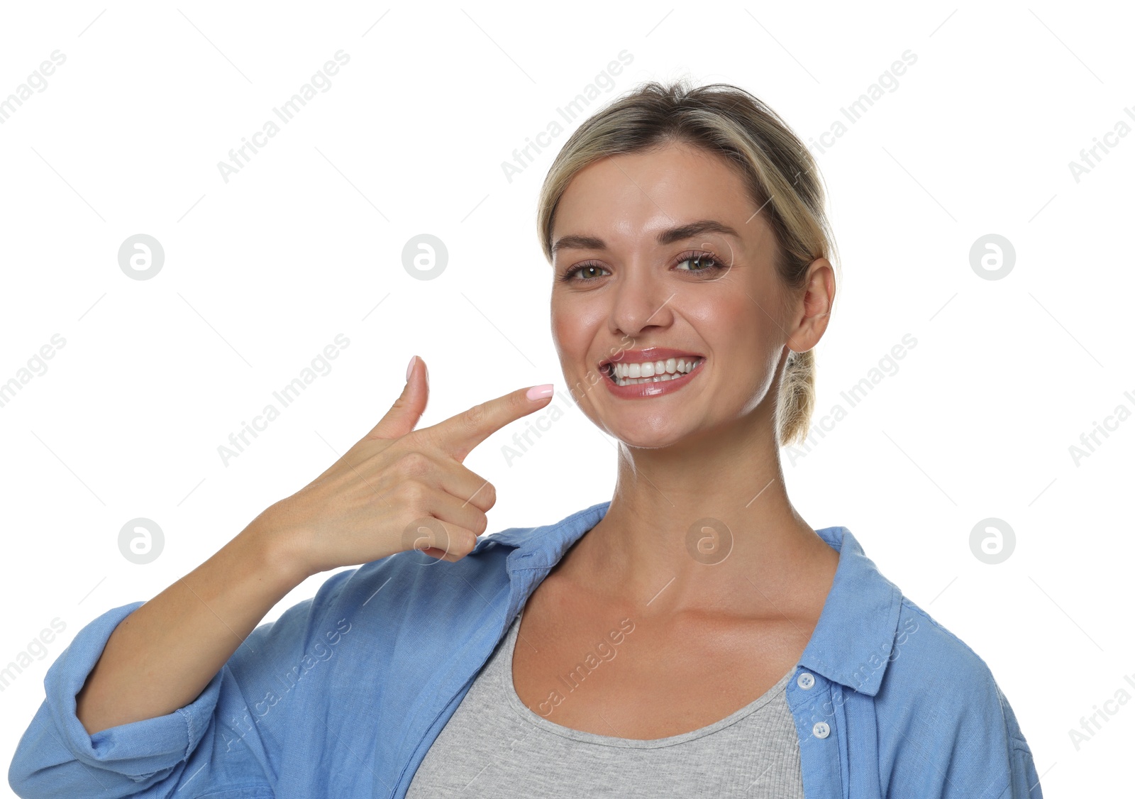 Photo of Woman pointing at her healthy teeth on white background