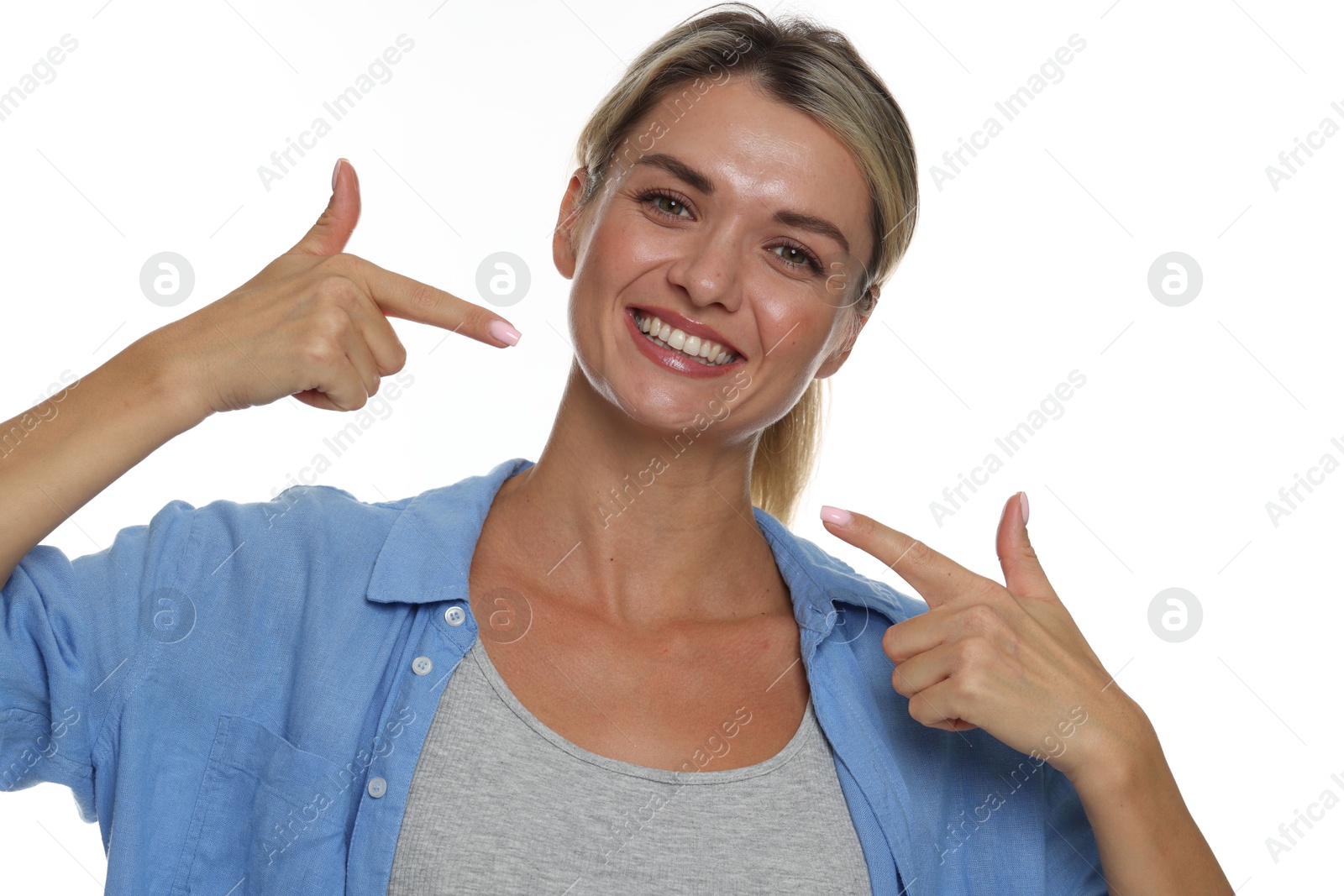 Photo of Woman pointing at her healthy teeth on white background