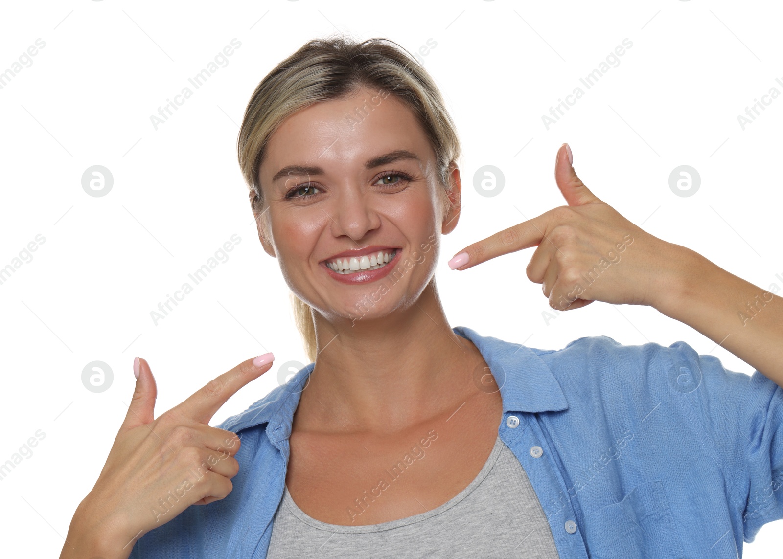 Woman pointing at her healthy teeth on white background Photo of Woman pointing at her healthy teeth on white background