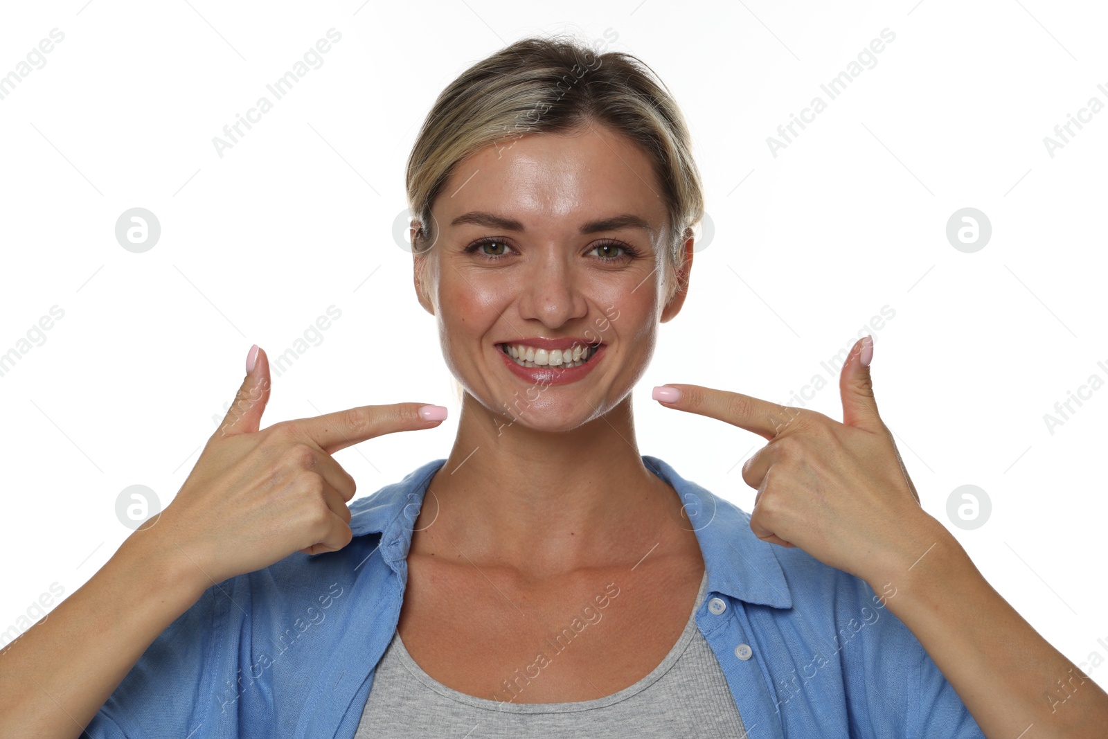 Photo of Woman pointing at her healthy teeth on white background