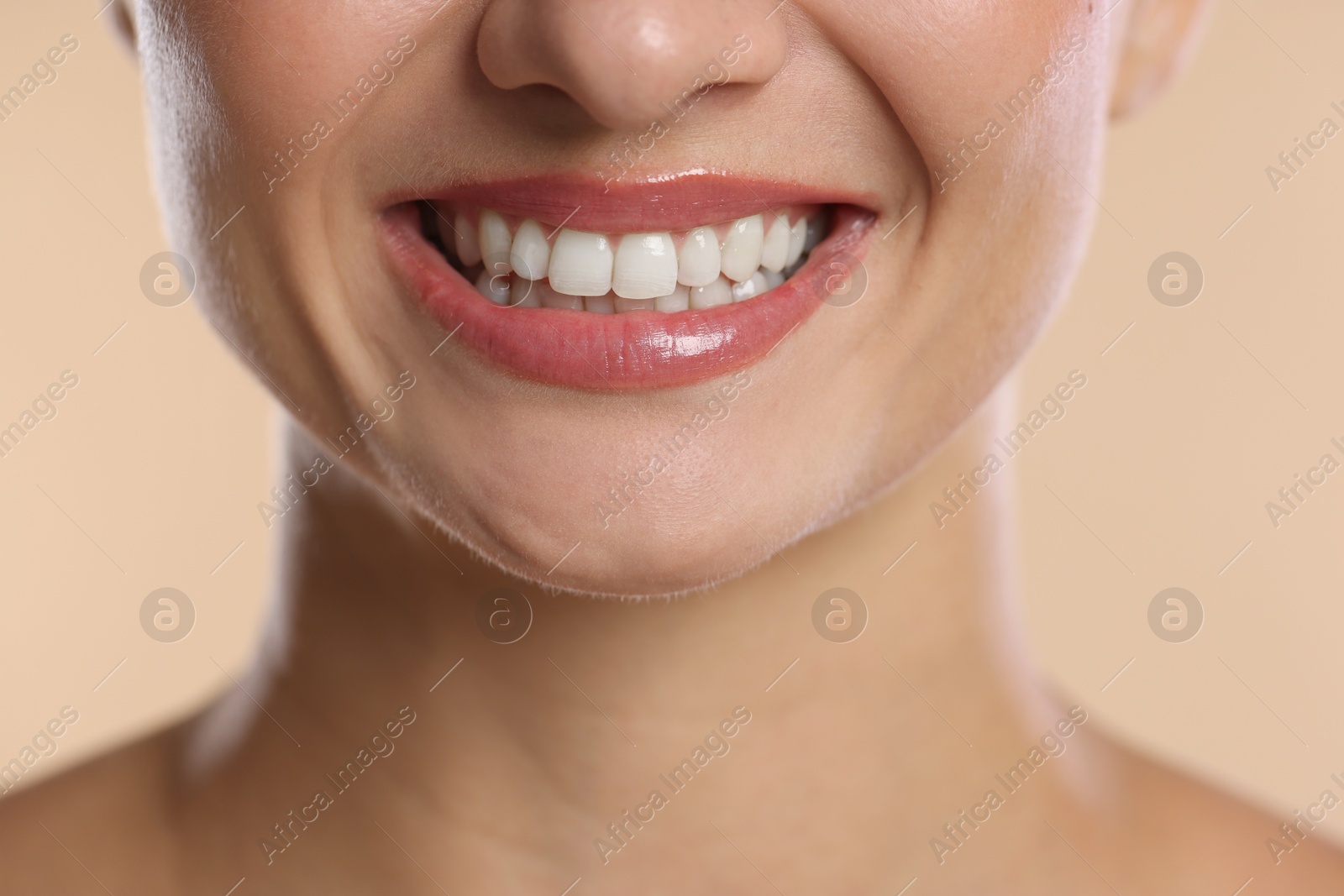 Photo of Woman with beautiful healthy teeth on beige background, closeup