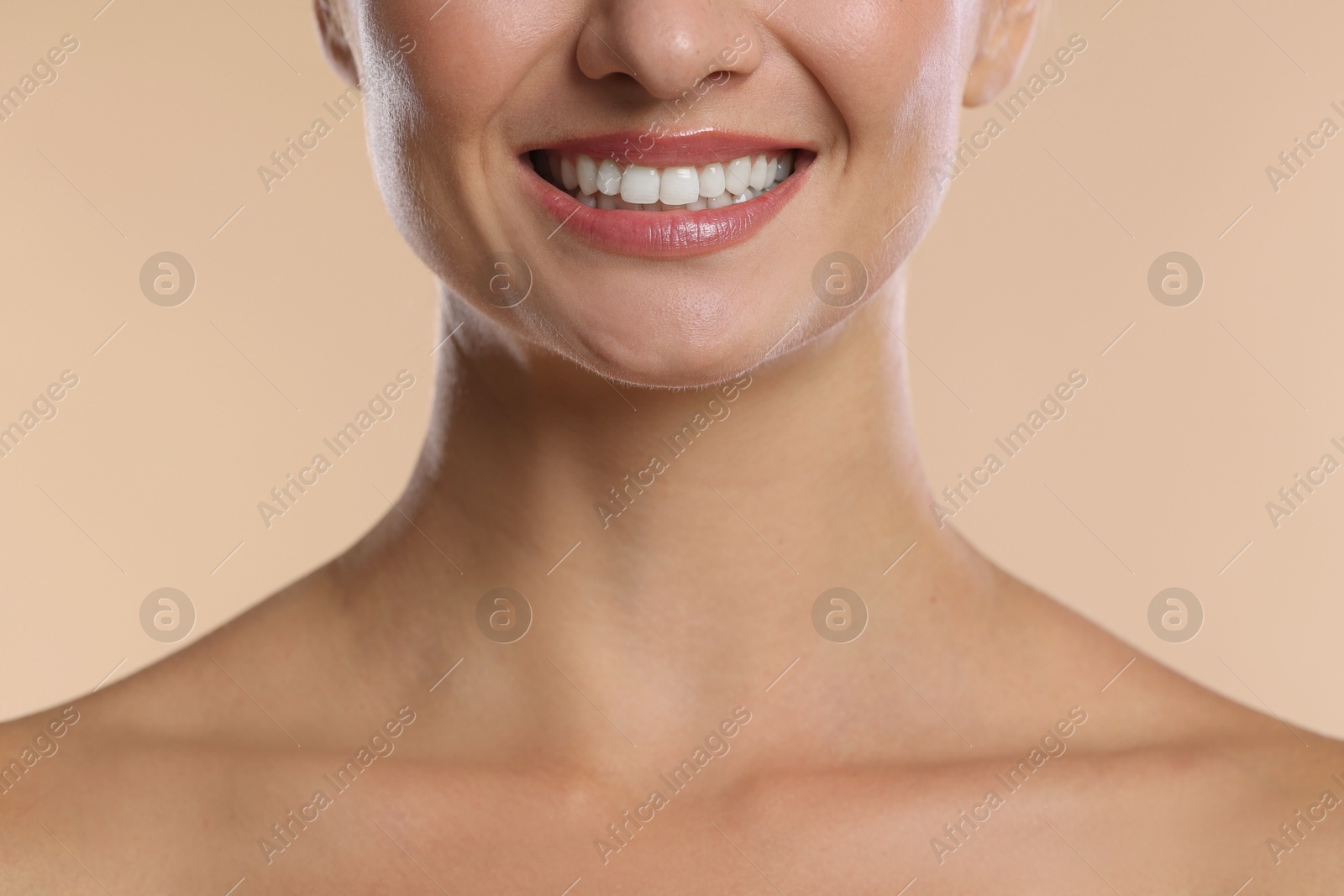Photo of Woman with beautiful healthy teeth on beige background, closeup