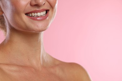 Photo of Woman with beautiful healthy teeth on pink background, closeup. Space for text