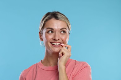 Photo of Woman with beautiful healthy teeth on light blue background