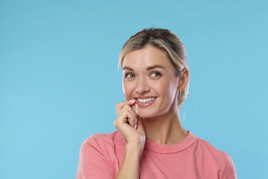 Photo of Woman with beautiful healthy teeth on light blue background. Space for text