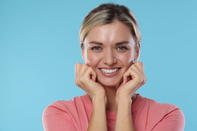 Photo of Woman with beautiful healthy teeth on light blue background