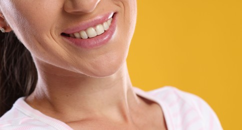 Photo of Woman with beautiful healthy teeth on yellow background, closeup