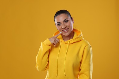 Photo of Woman with beautiful healthy teeth on yellow background
