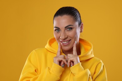 Photo of Woman with beautiful healthy teeth on yellow background