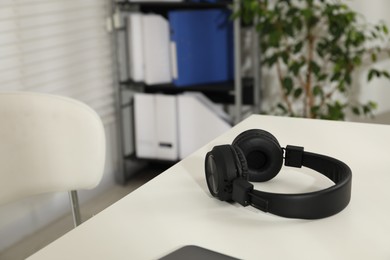 Photo of Wireless headphones on white background indoors, closeup. Space for text