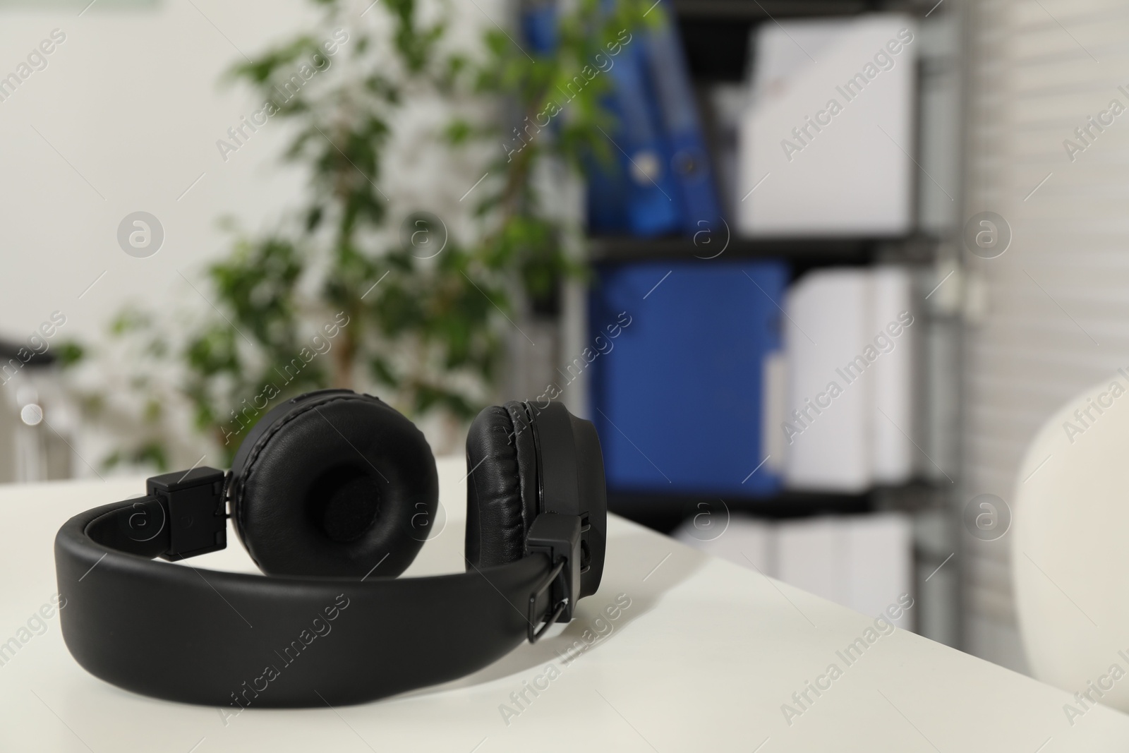 Wireless headphones on white background indoors, closeup. Space for text Photo of Wireless headphones on white background indoors, closeup. Space for text