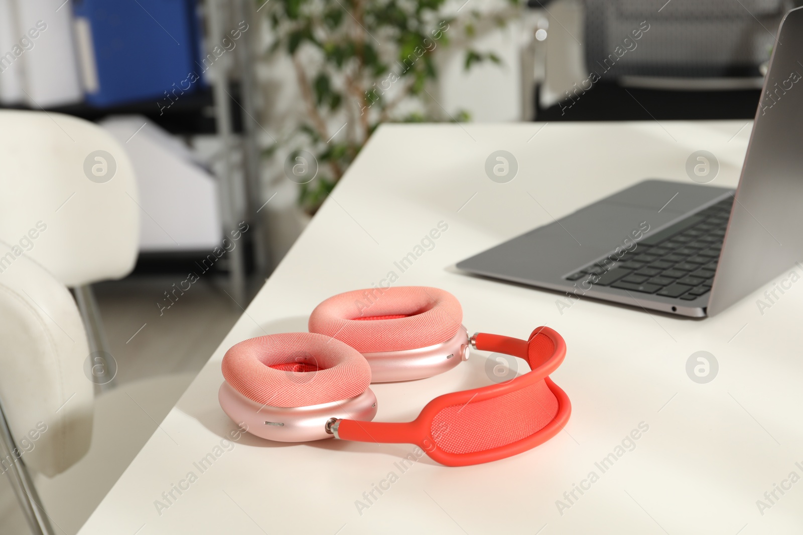 Wireless headphones and laptop on white background indoors, closeup. Space for text Photo of Wireless headphones and laptop on white background indoors, closeup. Space for text