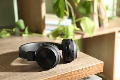 Photo of Black wireless on wooden table at home, closeup. Space for text