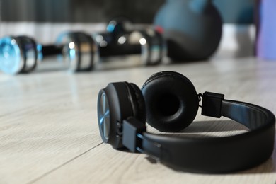 Photo of Wireless headphones on floor in gym, closeup. Space for text