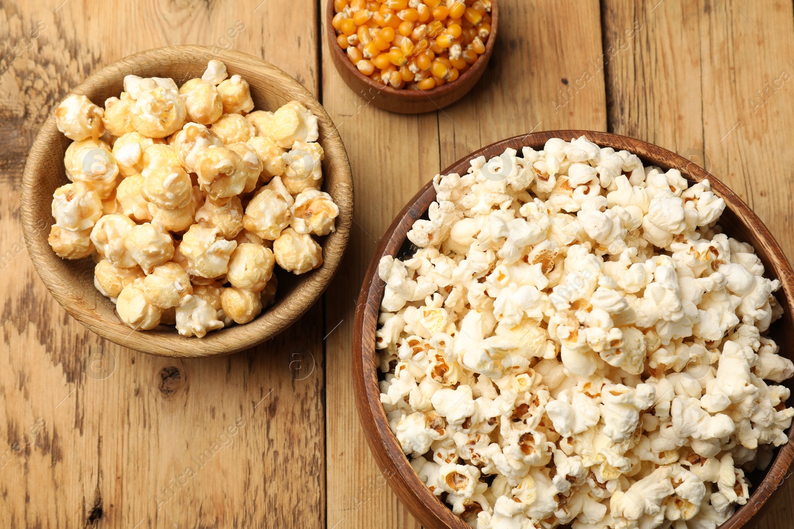 Tasty popcorn and corn kernels on wooden table, flat lay Photo of Tasty popcorn and corn kernels on wooden table, flat lay