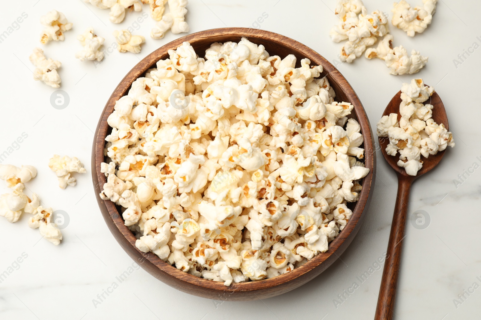 Photo of Tasty popcorn on white table, flat lay