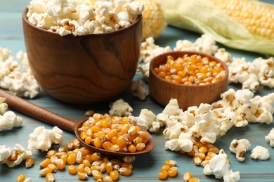 Photo of Corn kernels and tasty popcorn on blue wooden table, closeup