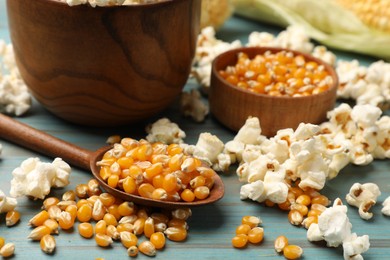 Photo of Corn kernels and tasty popcorn on blue wooden table, closeup