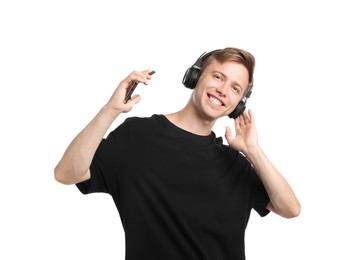 Photo of Happy man listening to music in headphones and dancing on white background