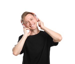 Photo of Happy man listening to music in headphones and dancing on white background